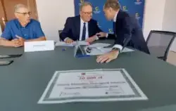 Trzch mężczyzn przy stole na którym leza dokumenty
