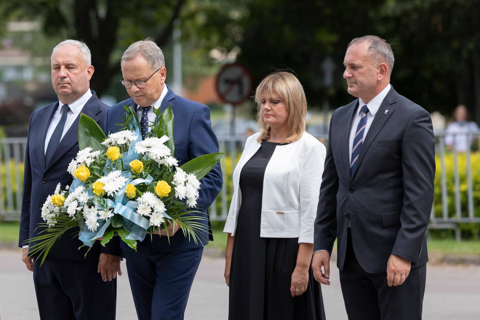 Od lewej: Zastępca Prezydenta Miasta ds. Techniczno-Inwestycyjnych Tadeusz Błędzki, Prezydent Miasta Janusz Stankowiak, Przewodnicząca Rady Miasta Anna Benert, Zastępca Prezydenta Miasta ds. Społecznych Maciej Kalinowski składają kwiaty pod pomnikiem Nauczania Sługi Bożego Jana Pawła II. 