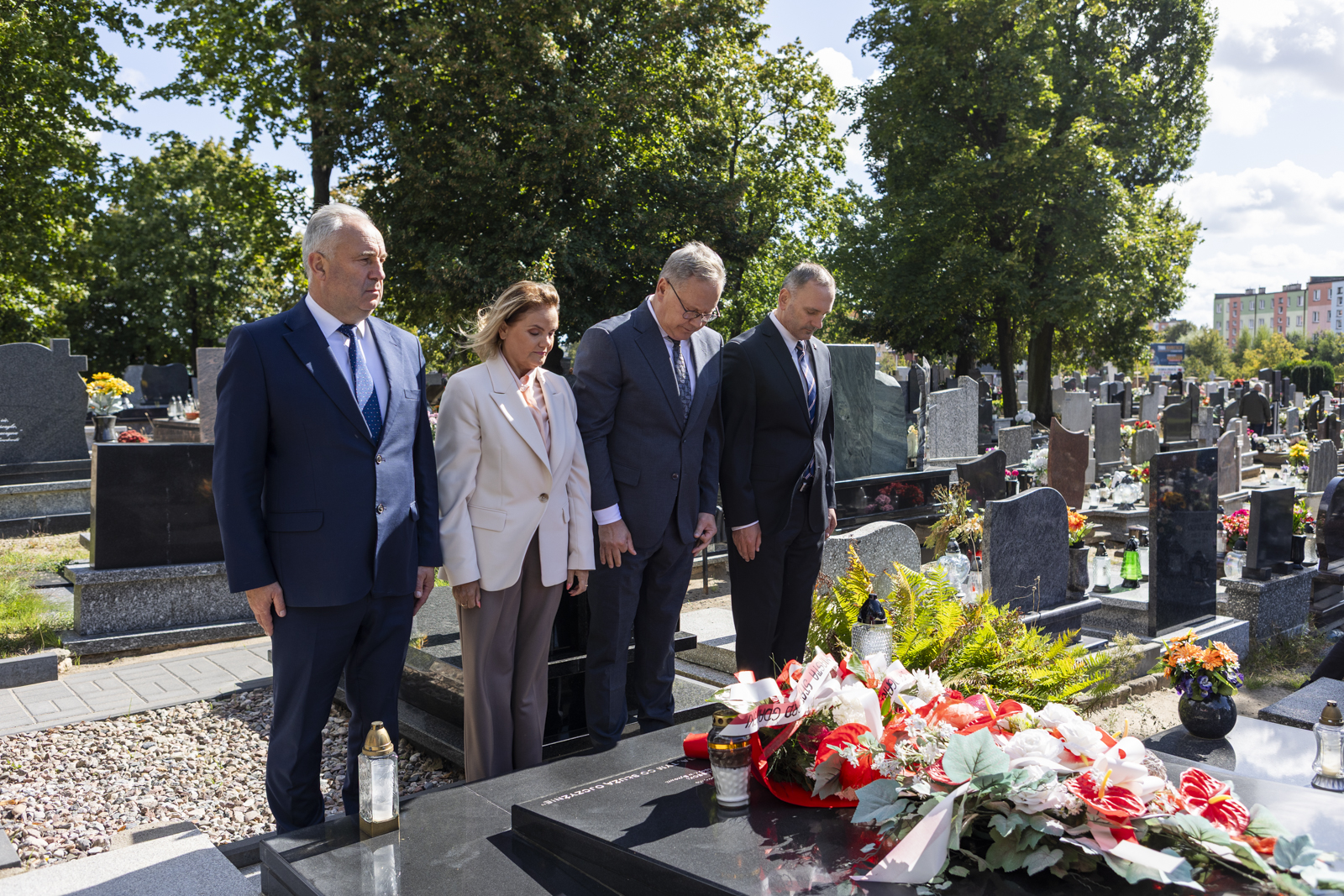 4 osoby składają kwiaty