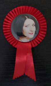 Zdjęcie kobiety w&nbsp;czerwonym kotylionie.