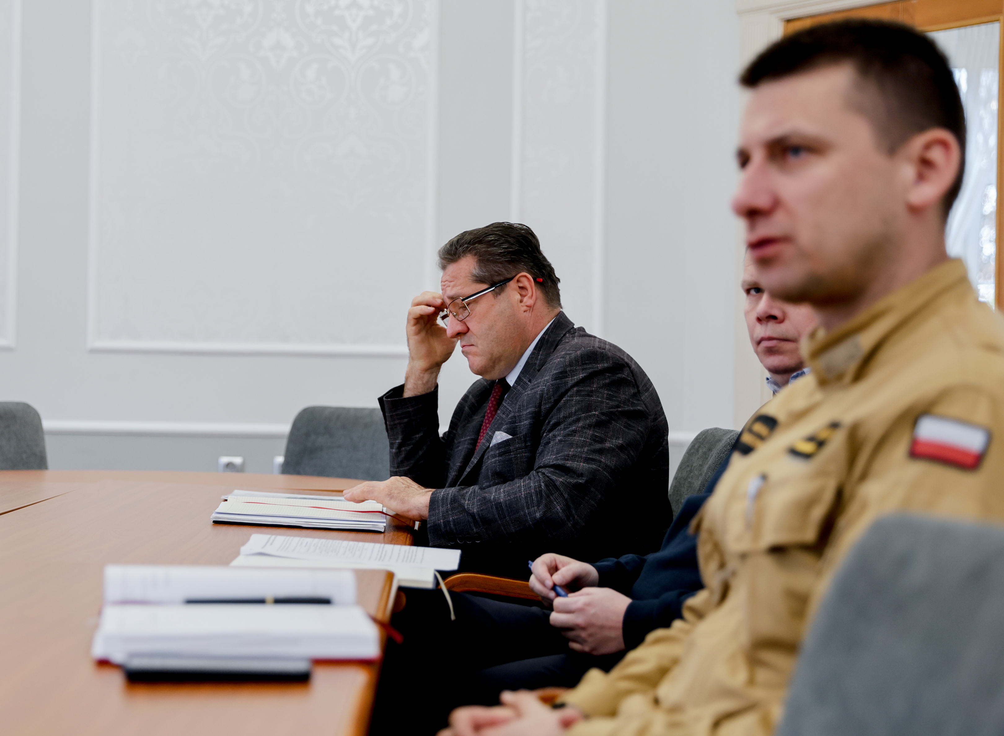 Mężczyzna w&nbsp;mundurze strażaka siedzi przy stole