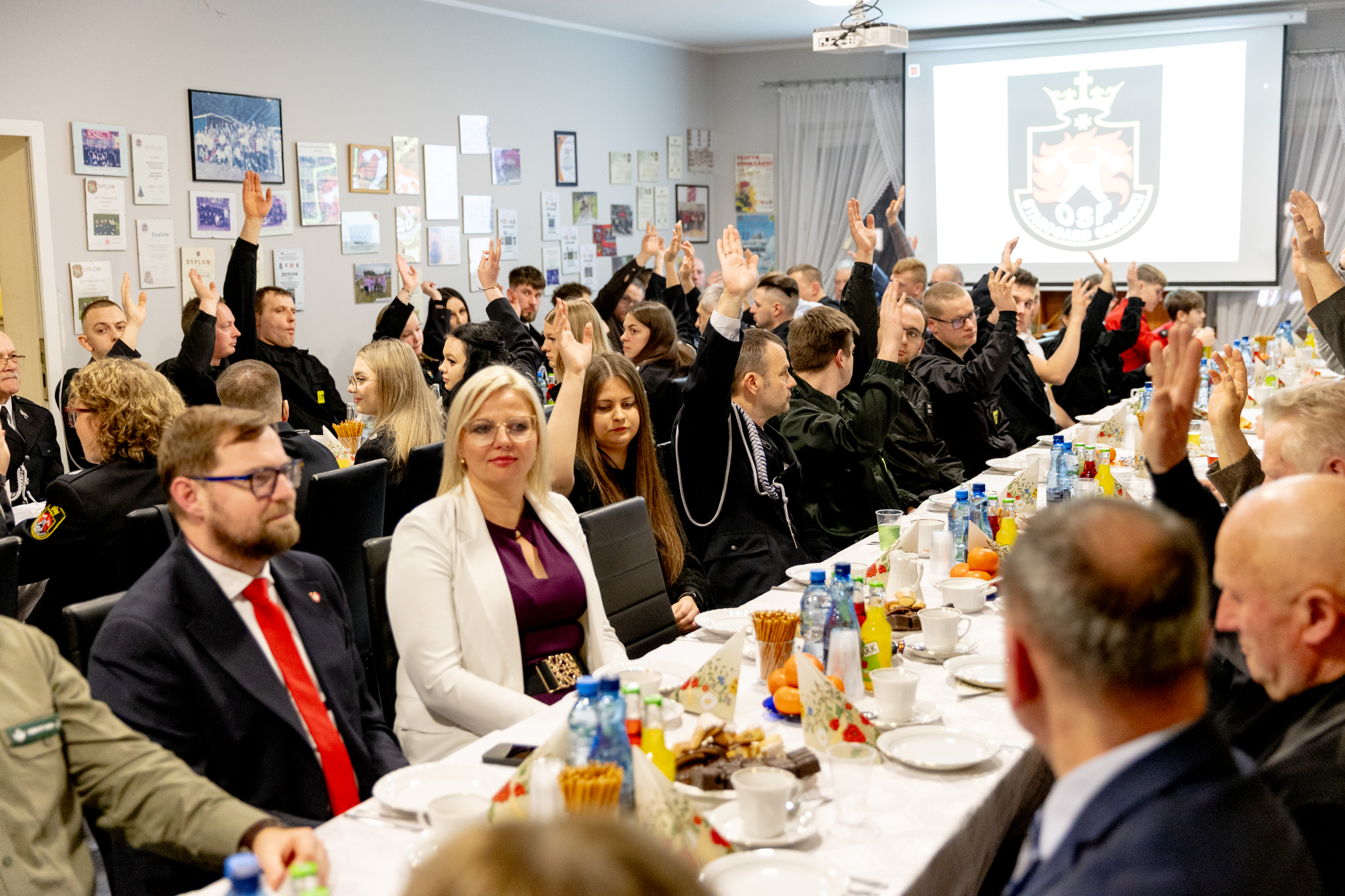strażacy z&nbsp;podniesionymi rękoma podczas głosowania 