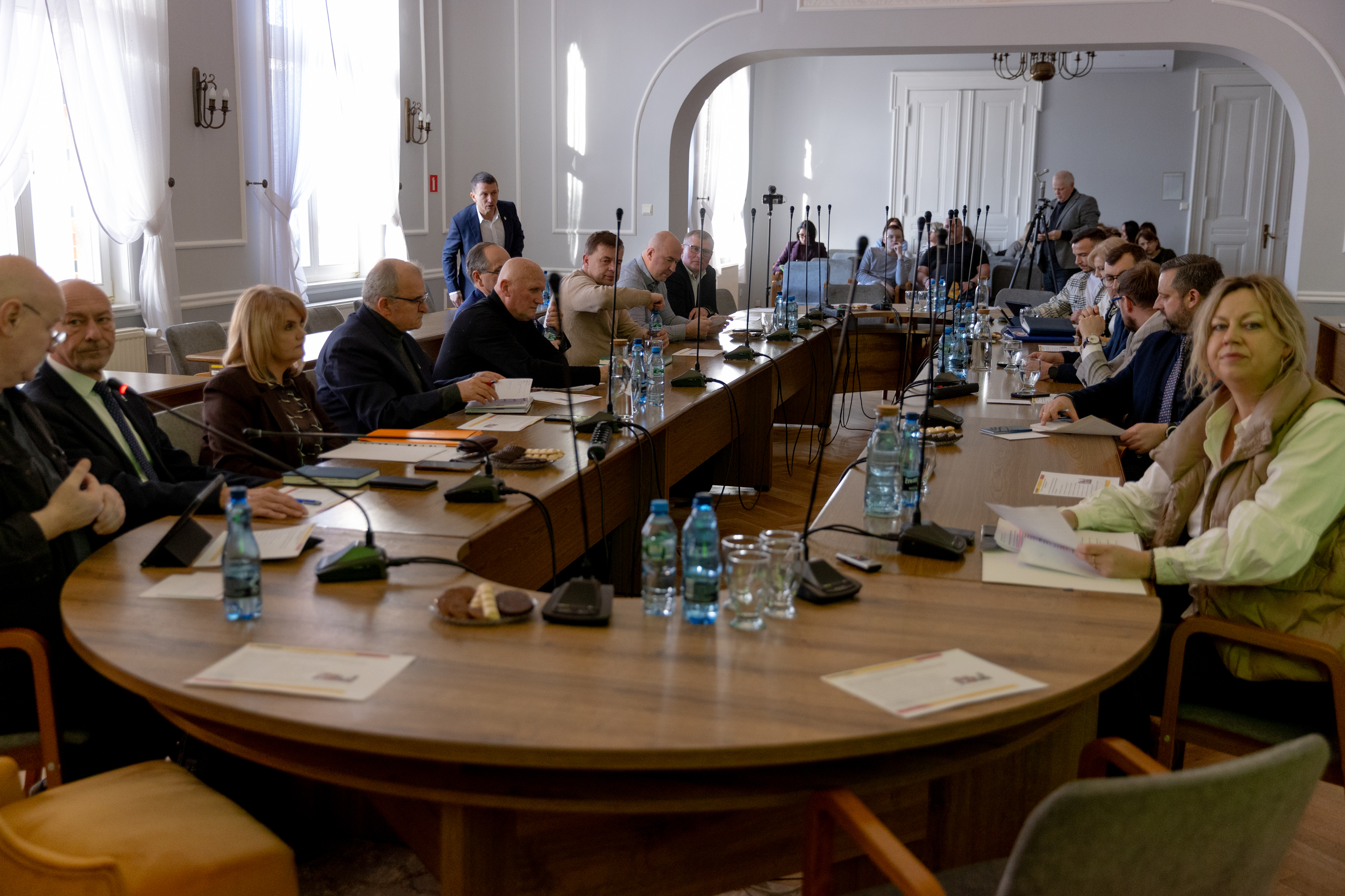 ludzie siedzą wok&oacute;ł stołu