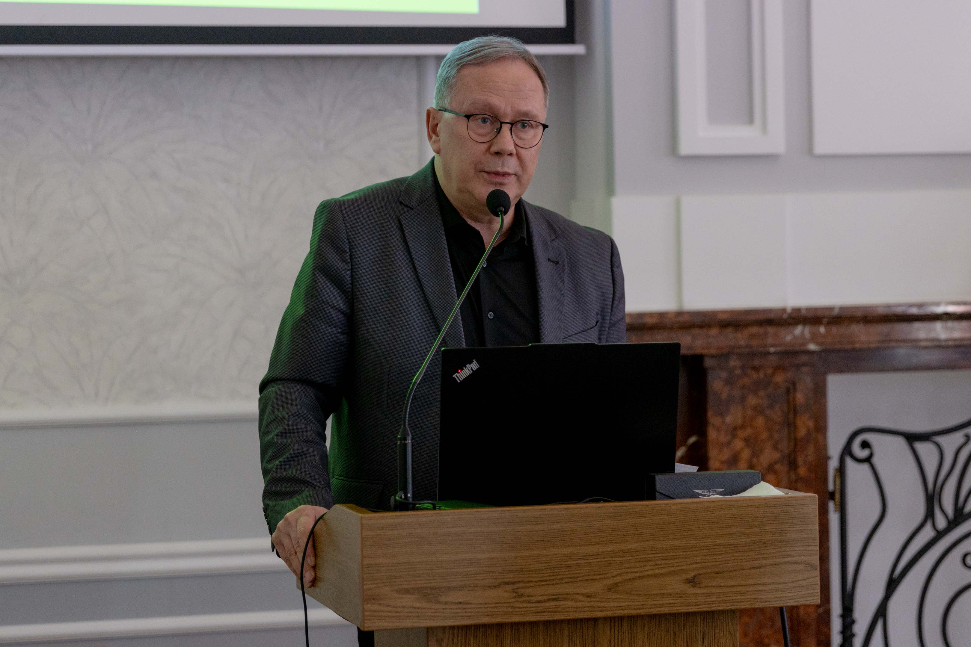 Przy m&oacute;wnicy mężczyzna w&nbsp;garniturze