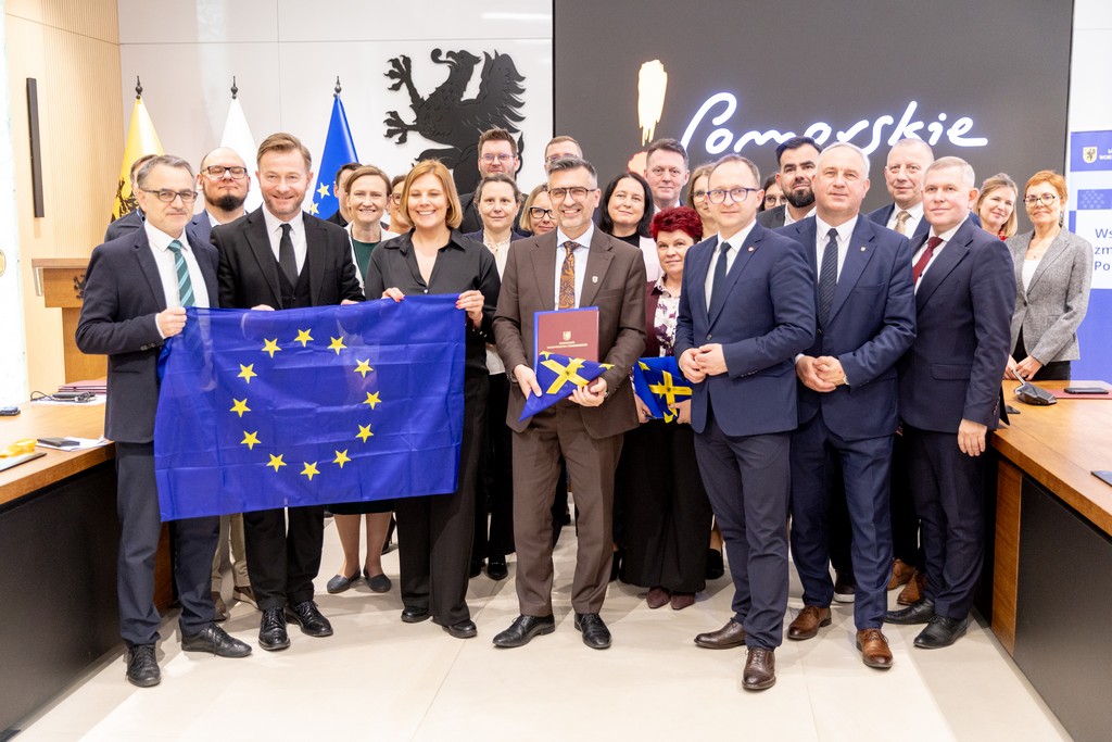 dużo ludzi stoi z&nbsp;flaga Unii Europejskiej
