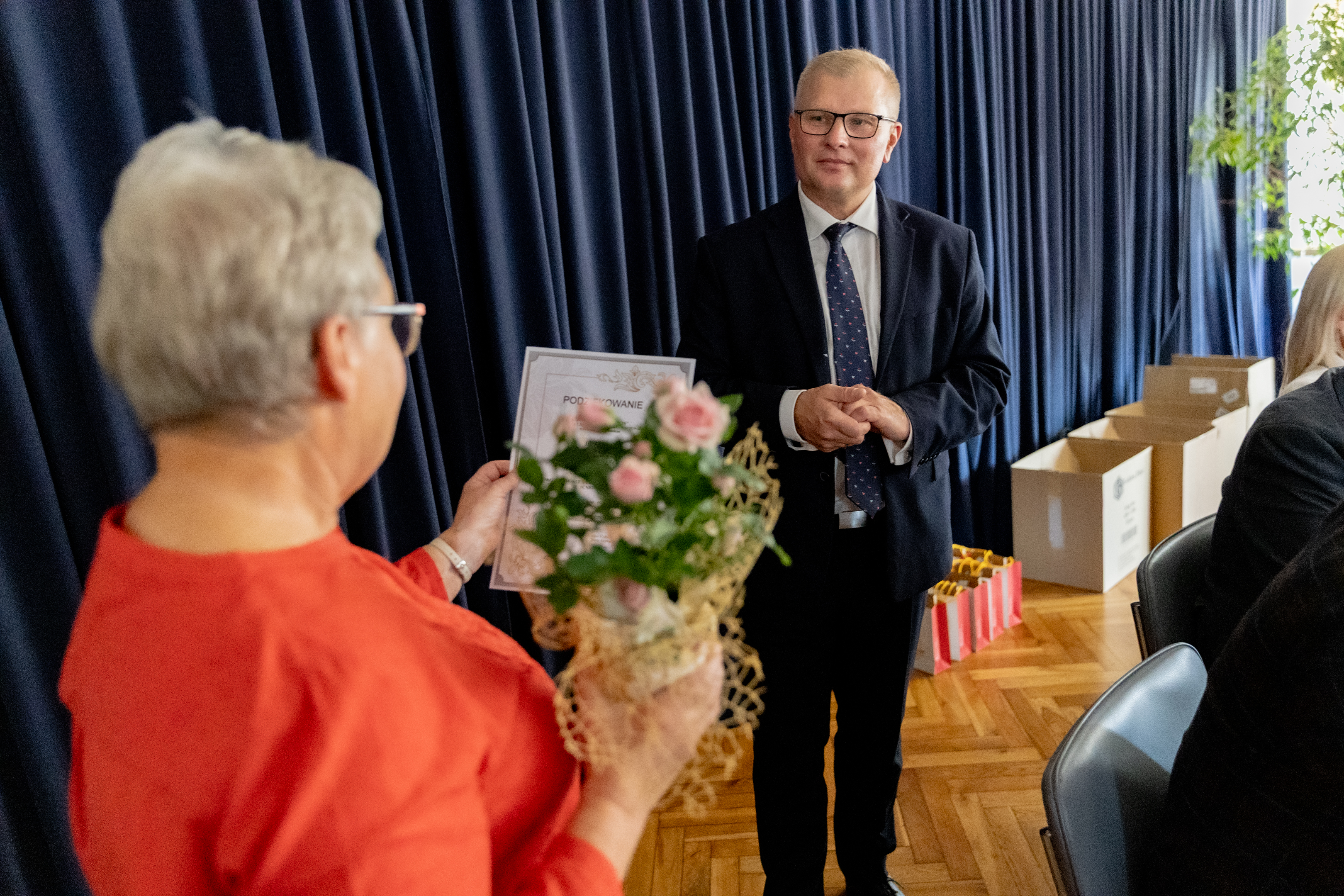 Kobieta z&nbsp;kwiatami naprzeciw mężczyzna w&nbsp;garniturze