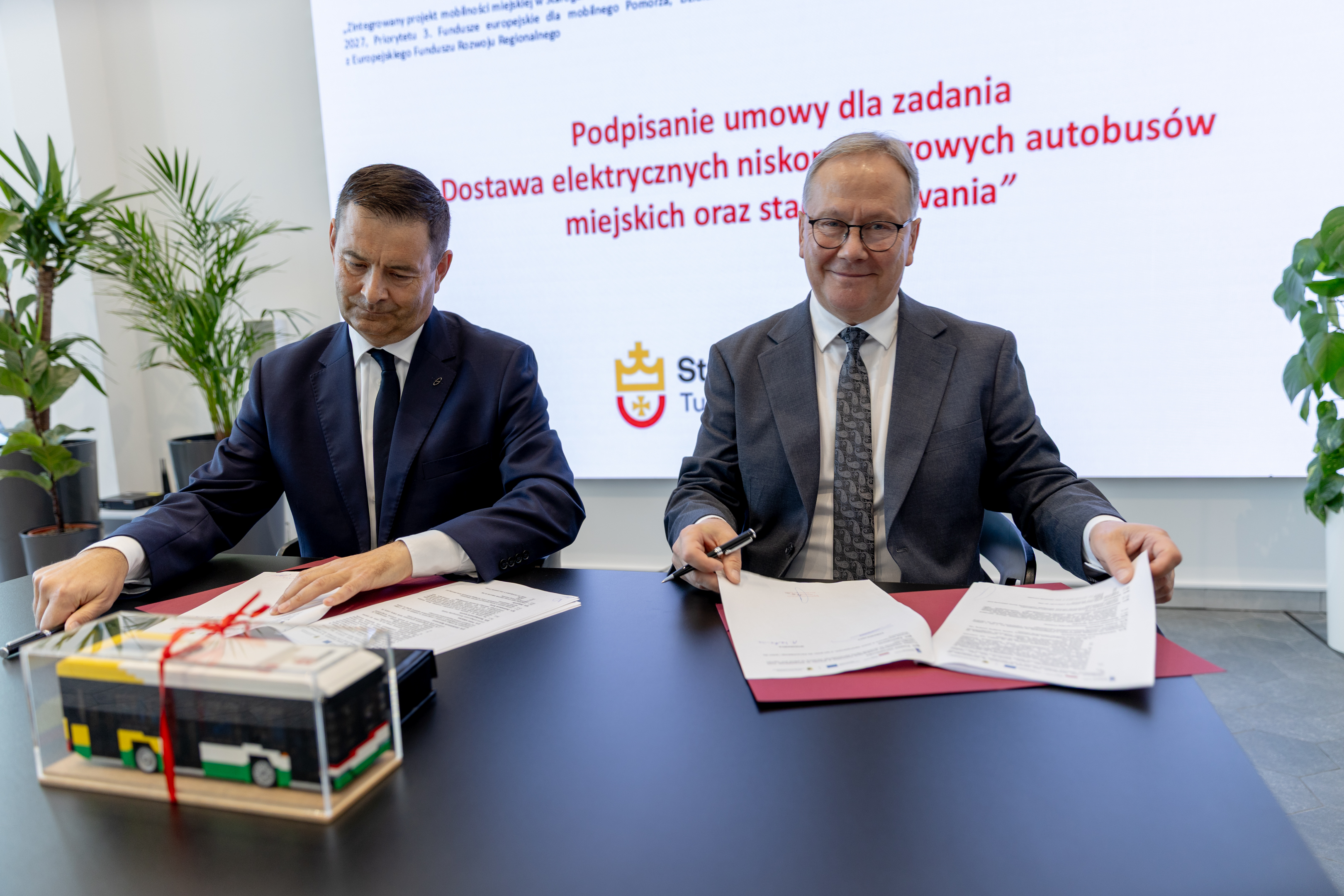 dw&oacute;ch mężczyzn podpisuje umowę 