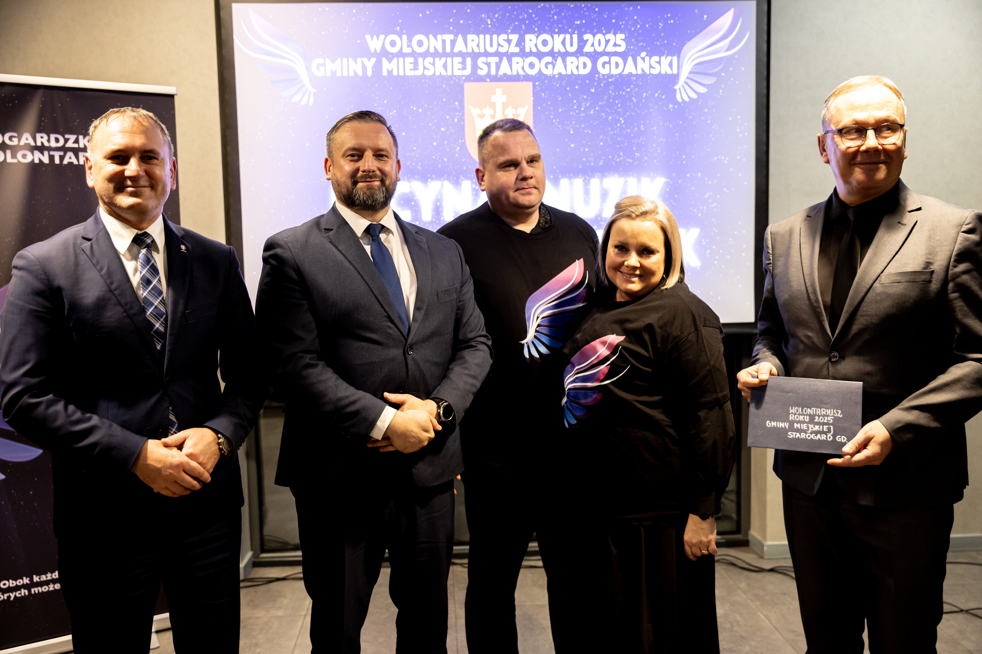 Mężczyżni w&nbsp;garniturach i&nbsp;para w&nbsp;czarnych koszulkach z&nbsp;niebiesko r&oacute;żowym skrzydłem - kobieta i&nbsp;męzczyzna