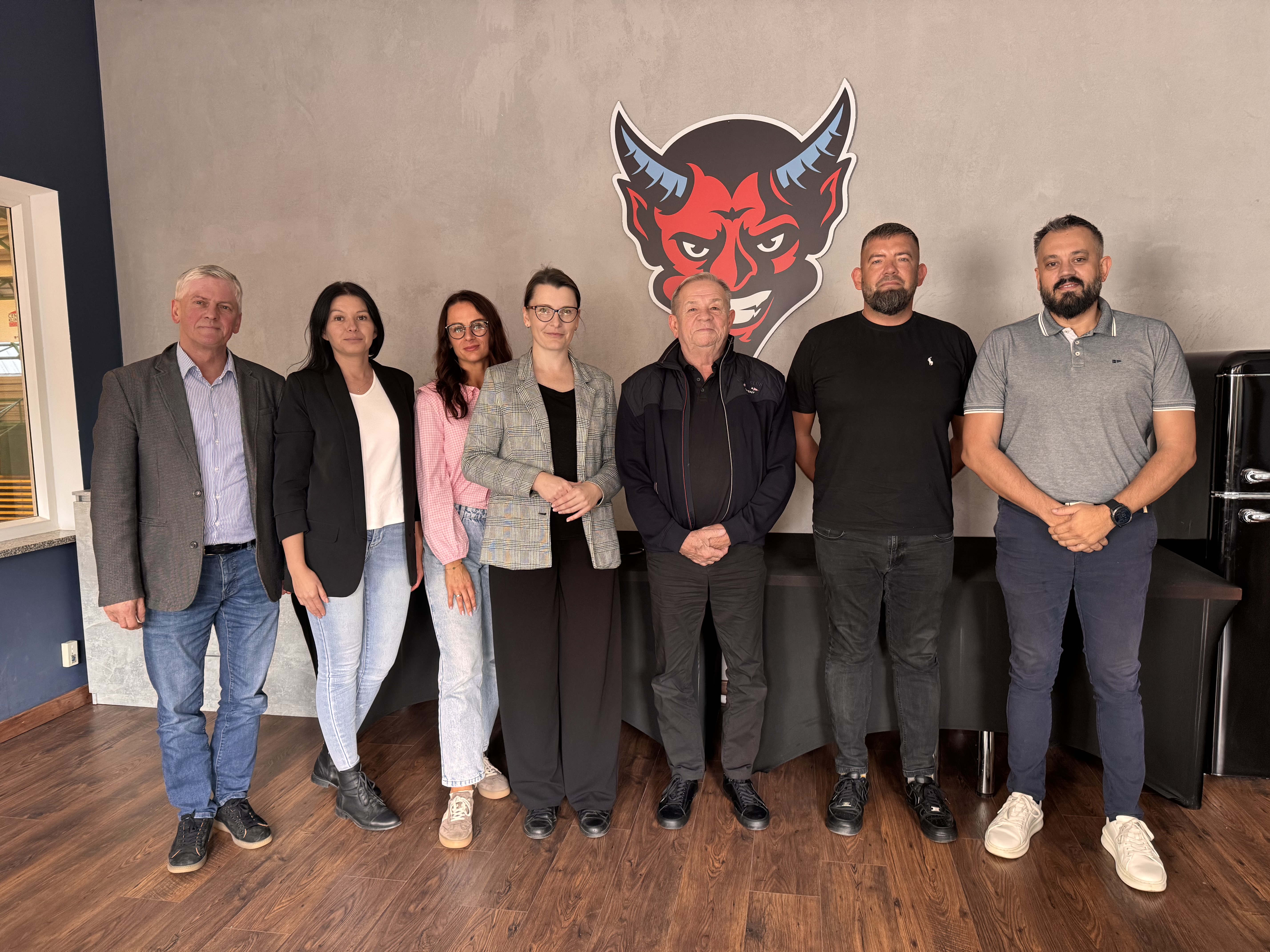 Kilka os&oacute;b stoi pod logo Kociewskich Diabłow