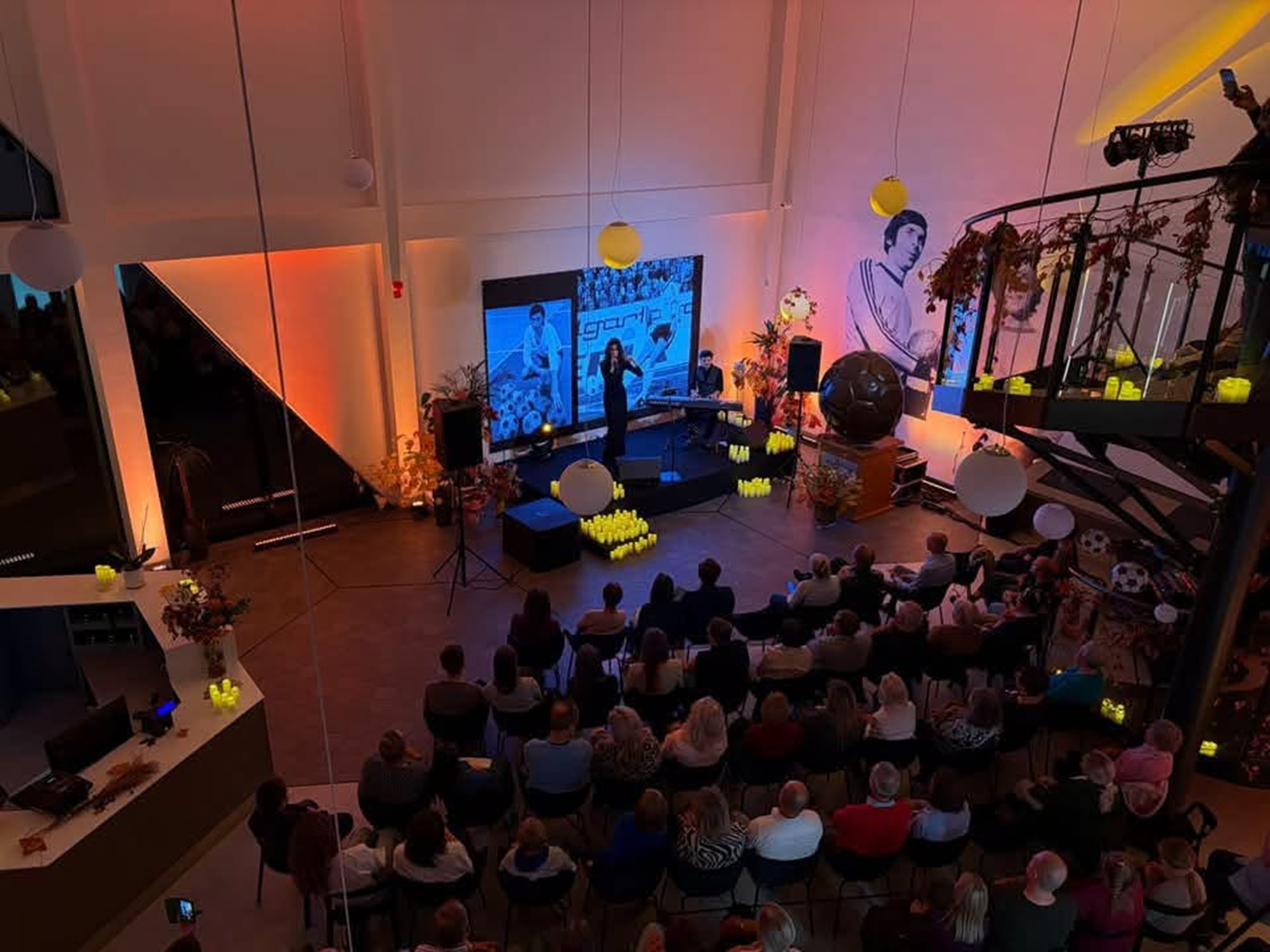 Sala pełna ludzi słucha koncertu.