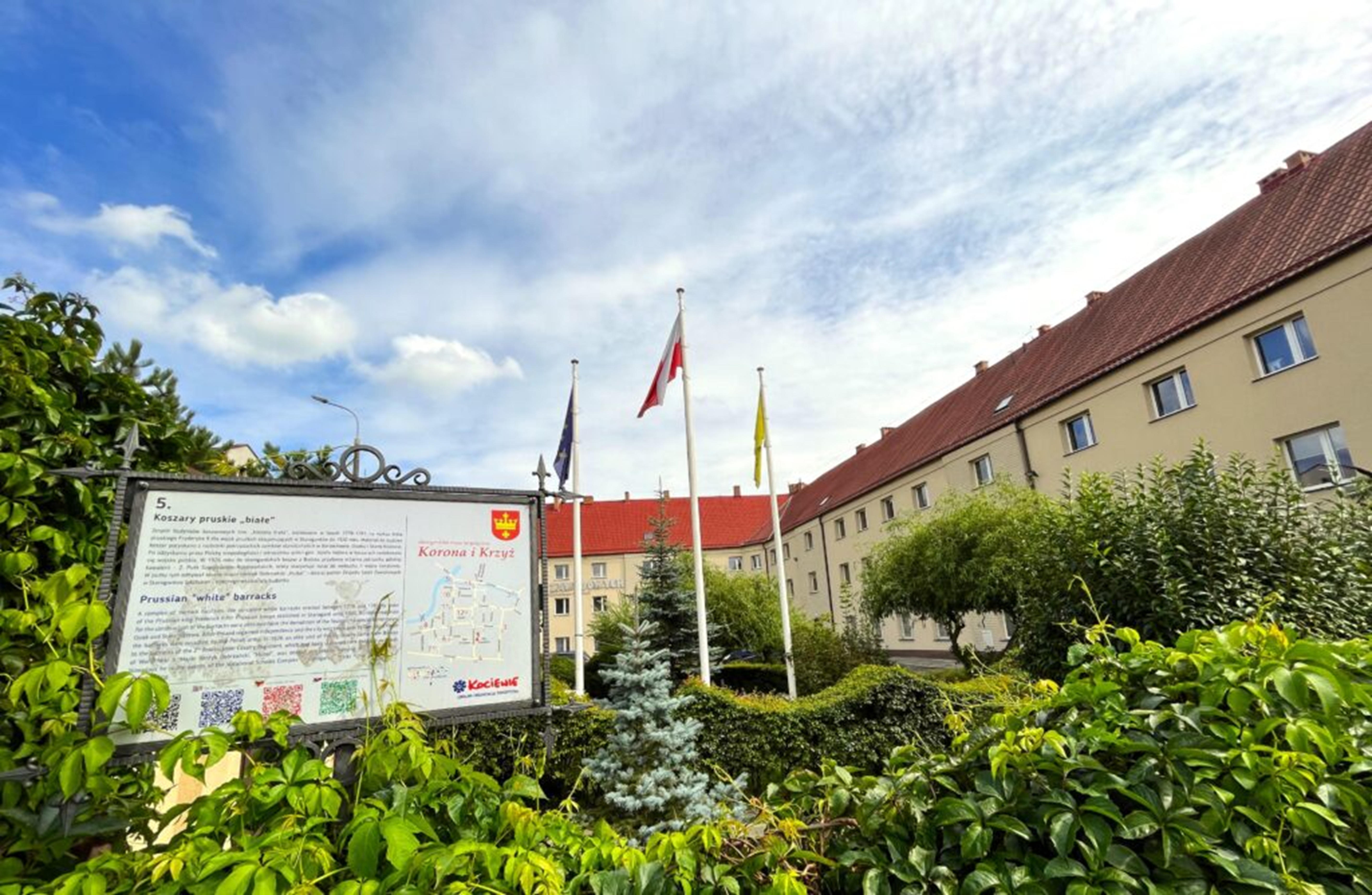 Beżowy budynek z&nbsp;czerwona dach&oacute;wką.