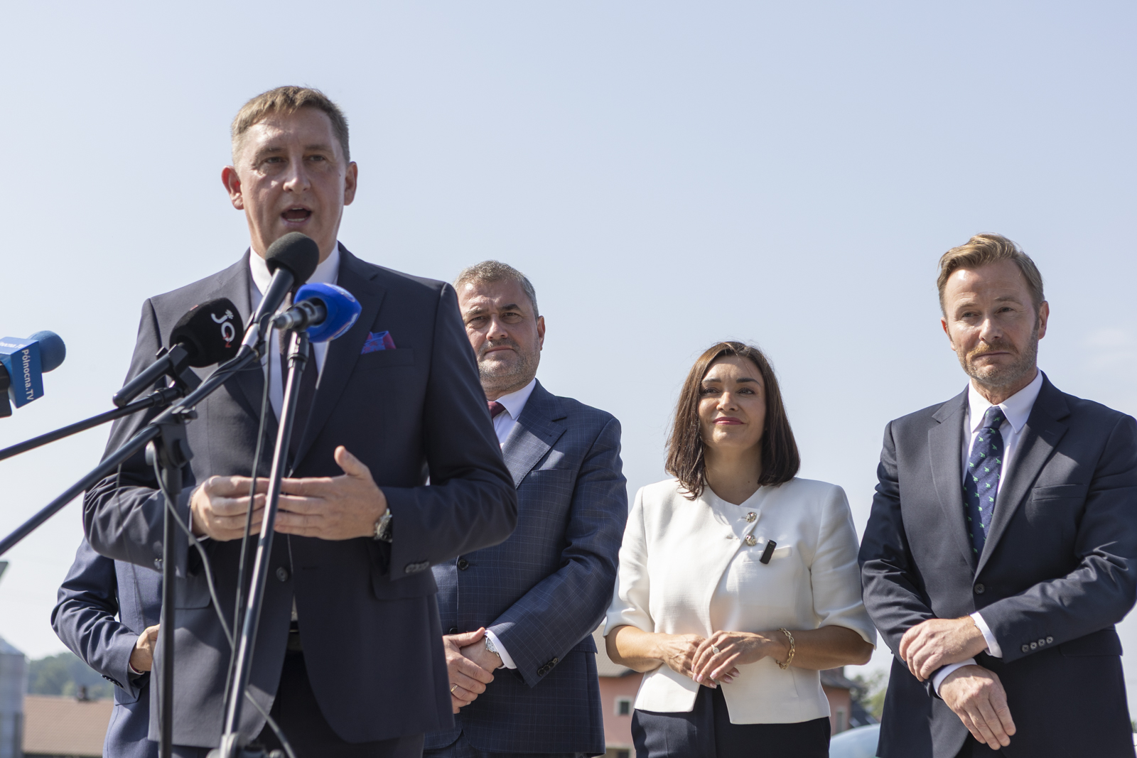 mężczyzna w&nbsp;garniturze przy mikrofonie