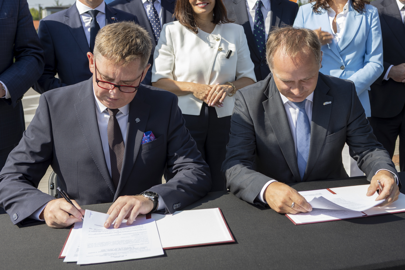 dw&oacute;ch mężczyzn w&nbsp;garniturach podpisują umowę