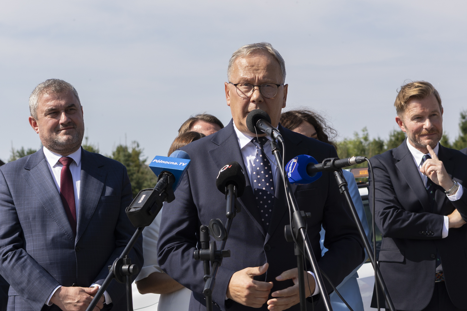 mężczyzna w&nbsp;garniturze przy mikrofonie