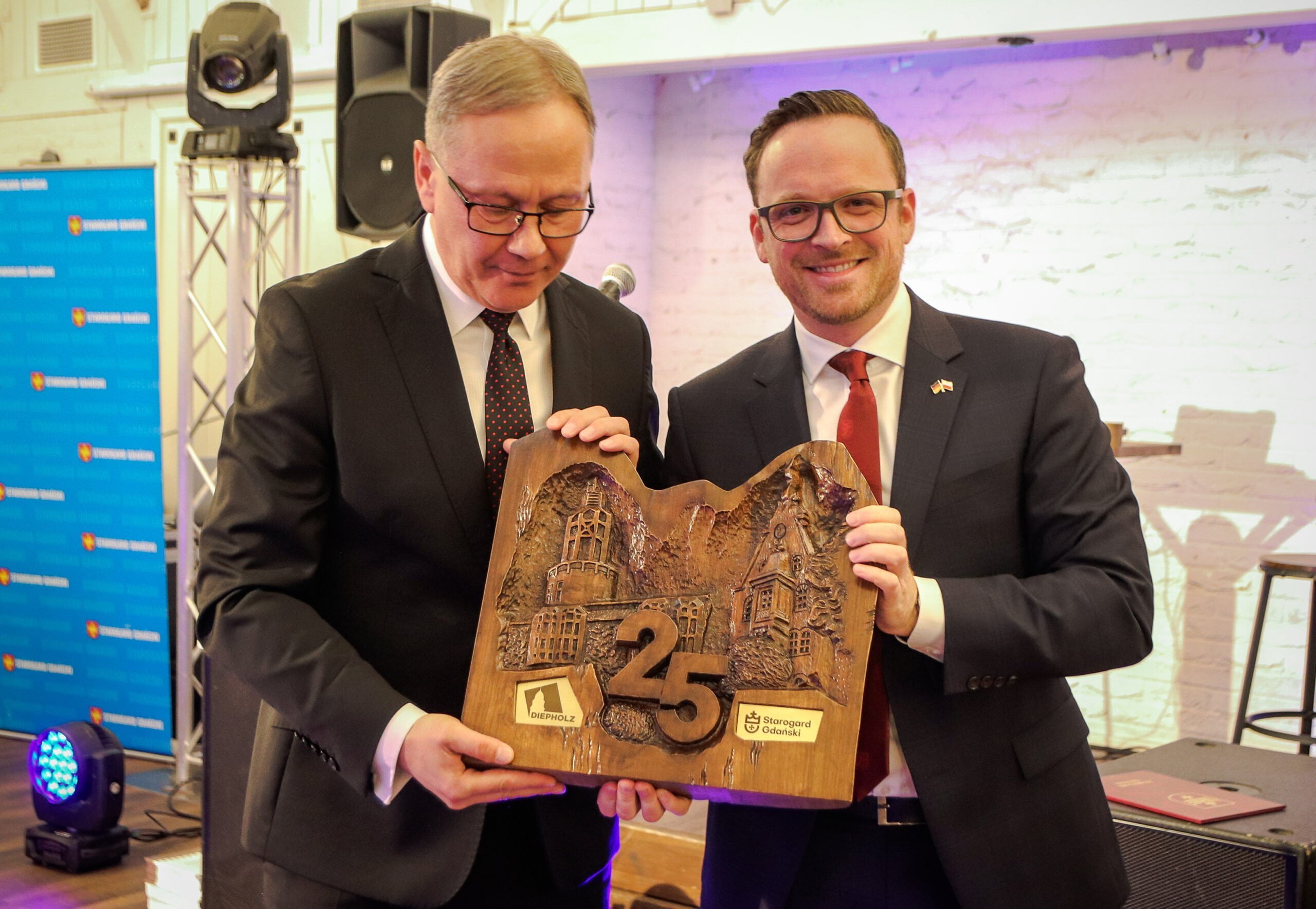 Dwaj mężczyżni trzymają rzeżbę z okazji 25-lecia współpracy polsko-niemieckiej