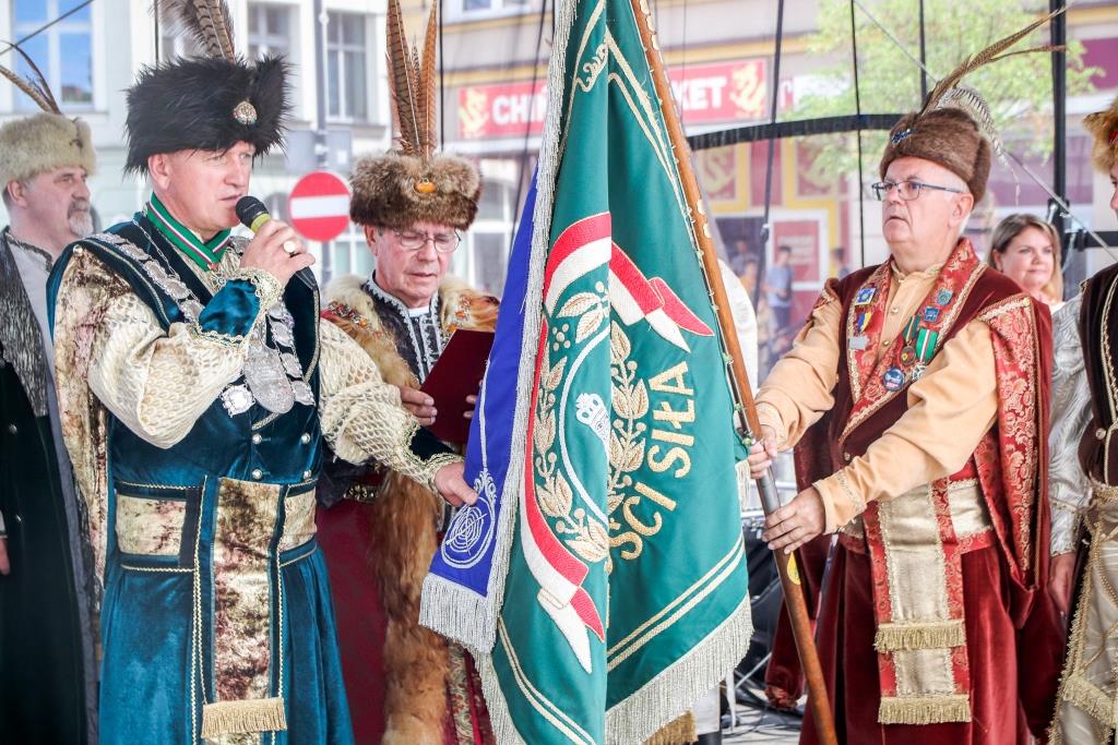 Uroczysta Intronizacja Króla Kurkowego. Bracia Kurkowi stoją na scenie. Nowy Król składa ślubowanie. 