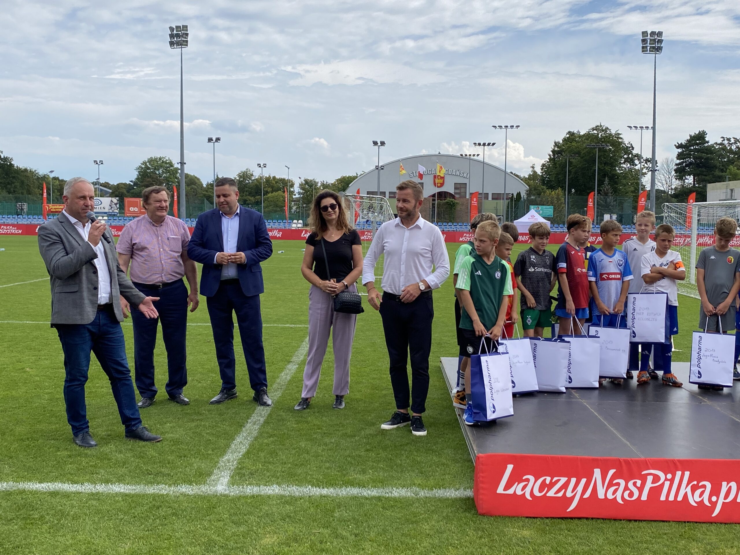 Przedstawiciele władz samorządowych witają młodych piłkarzy.