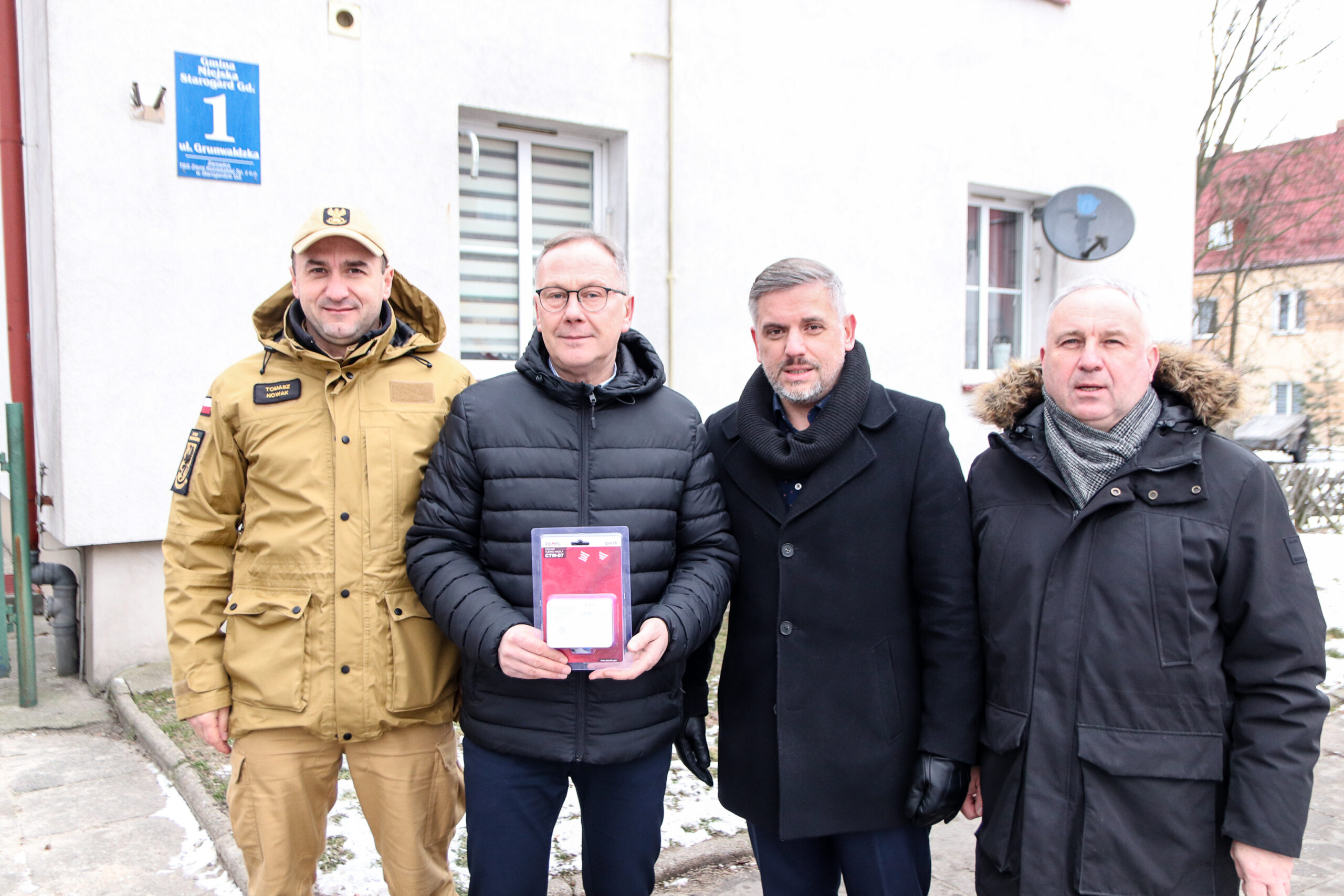 Czterech mężczyzn na tle bloku