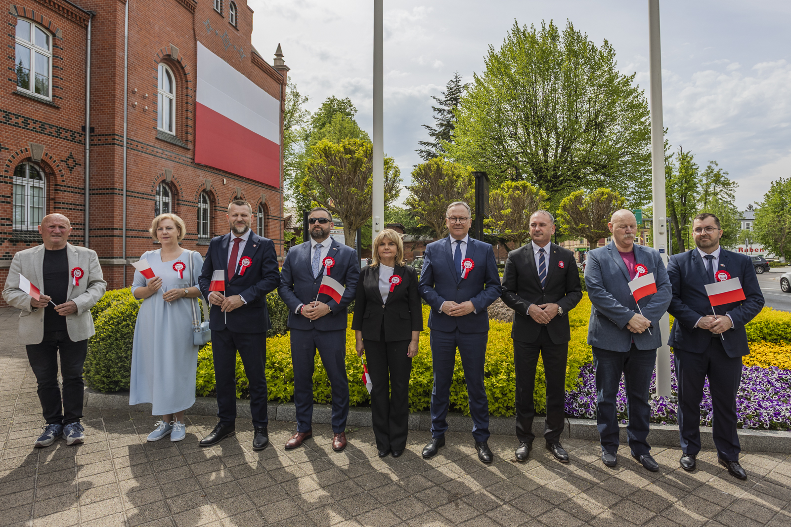 Prezydent Miasta Janusz Stankowiak, wiceprezydent Maciej Kalinowski, przewodnicząca Rady Miasta Anna Benert oraz radni Rady Miasta podczas uroczysego wciągnięcia flagi Rzeczpospolitej Polskiej na maszt przed Urzędem Miasta. 