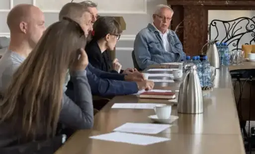  Członkowie rady siedzą przy stole.