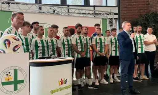 Członkowie drużyny stoją na scenie.