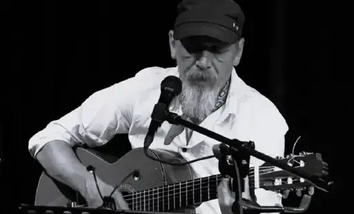 Na zdjęciu Radosław Ciecholewski grający na gitarze.