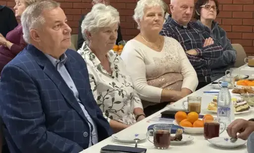 Emeryci siedzą przy stole.