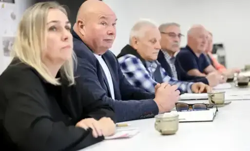 Kobieta i czterech mężczyzn siedzą przy stole