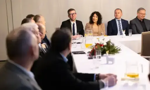 Ludzie siedzą przy stole i dyskutują