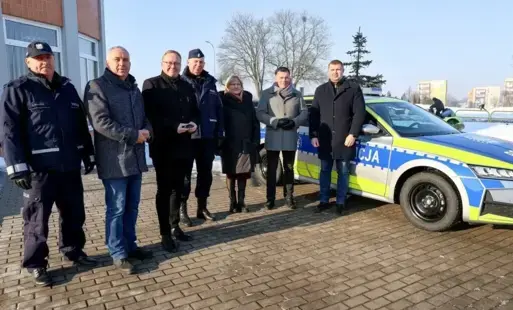 Ludzie stoją przy samochodzi policyjnym