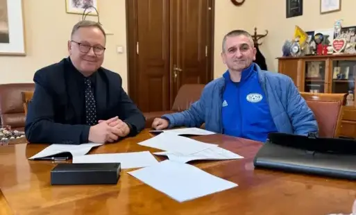 Dwóch mężczyzn siedzi przy stole.