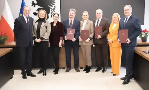 osiem osób stoi w rzedzie z teczkami 4 kobiety i czterech męzczyzn