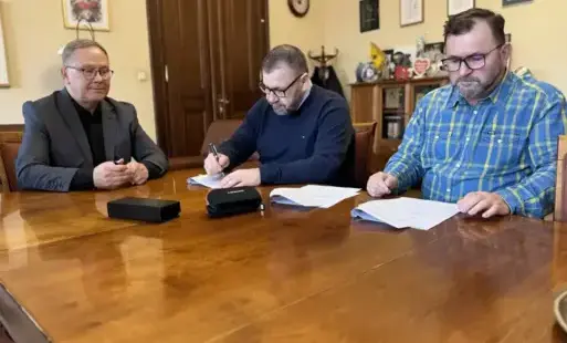 3 mężczyzn podpisuje umowy.