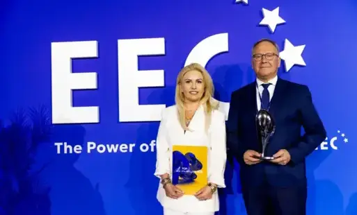 Kobieta w białym garniturze mężczyzna w czarnym stoja na tle granatowej scianki