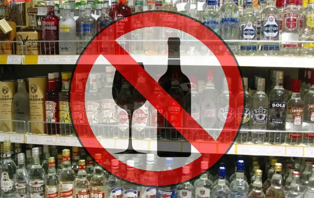 półki z alkoholem w tle na pierwszym planie znak zakazu sprzedaży