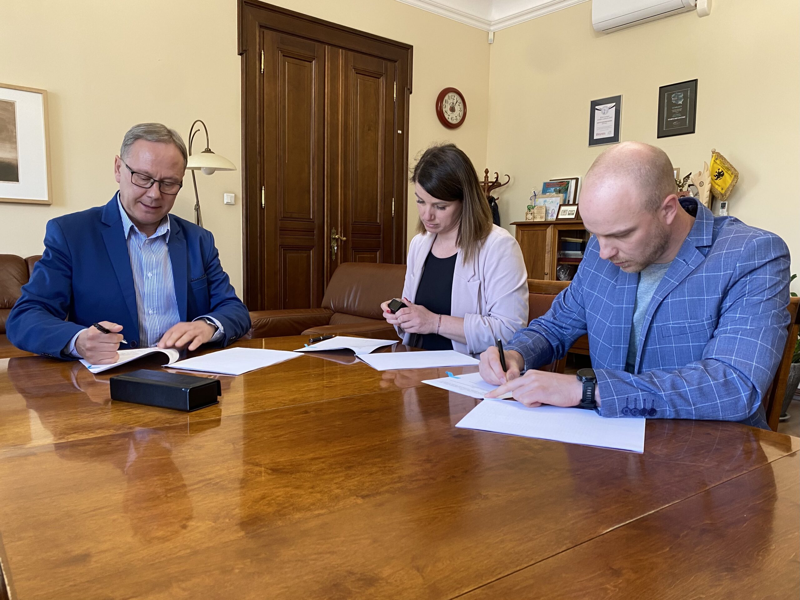Prezydent Miasta Janusz Stankowiak, Katarzyna Wątka i Paweł Demski ze stowarzyszenia Start On podpisują umowę na dofinansowanie projektu.