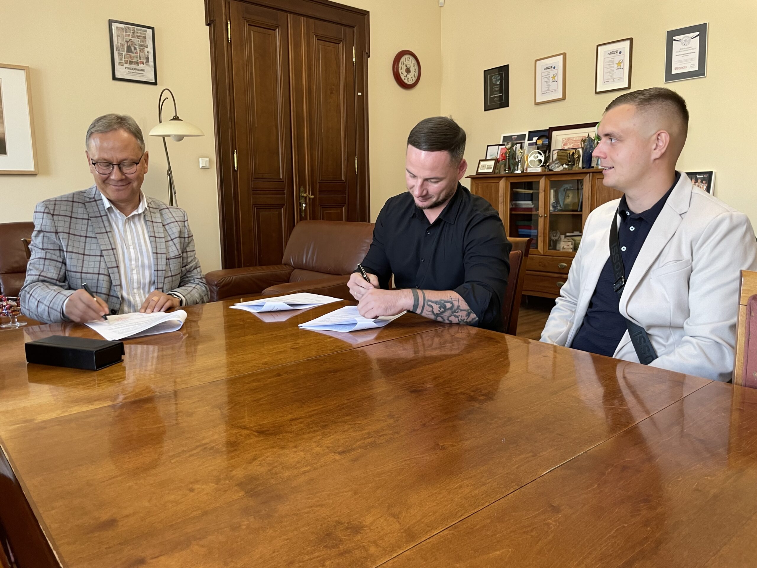 Panowie podpisują umowę w gabinecie prezydenta.